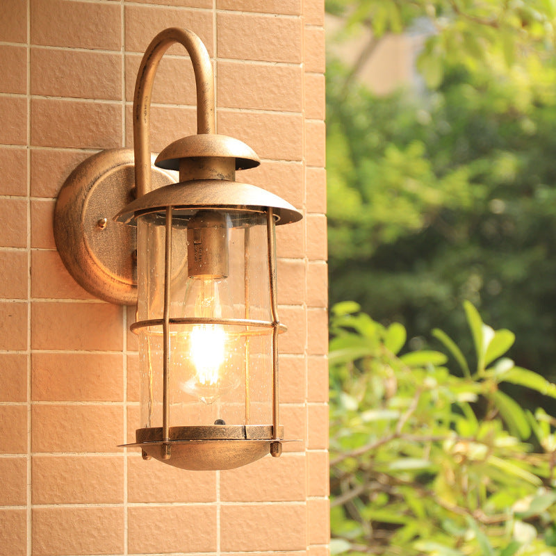 Coastal Clear Glass Wall Sconce With Brass Cage And Cylinder Light