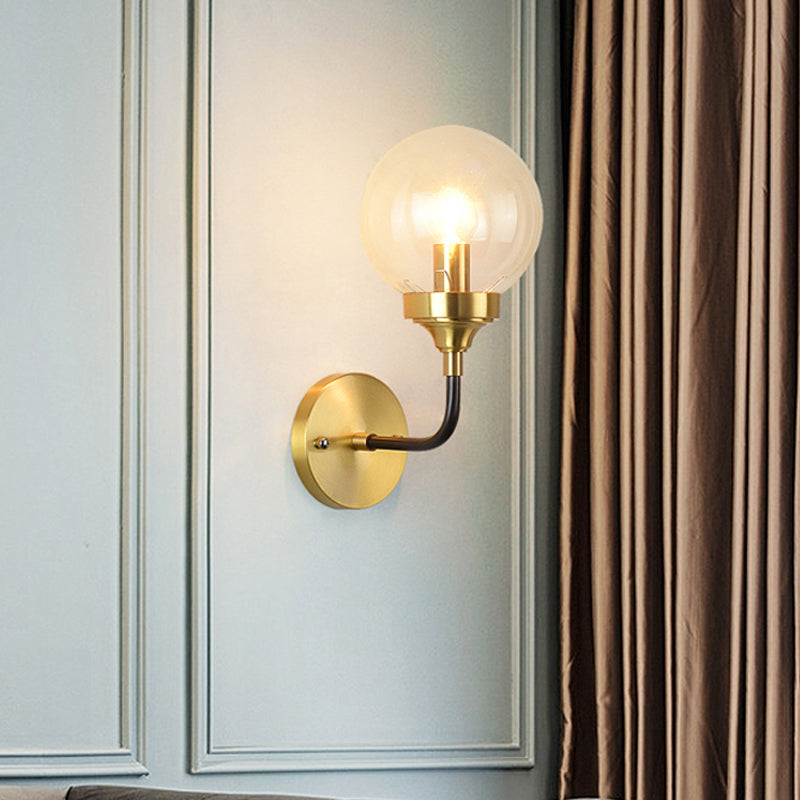 Clear Glass Globe Wall Sconce Light Fixture - Simple Brass With Curved Arm