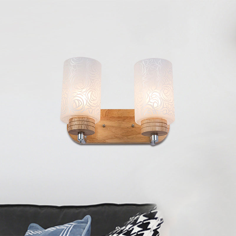 Modern 2-Headed White Glass Cylinder Wall Sconce With Wood Mount And Rose Pattern