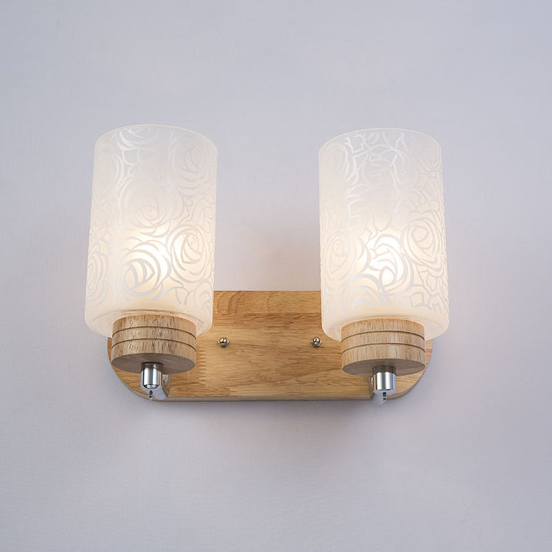 Modern 2-Headed White Glass Cylinder Wall Sconce With Wood Mount And Rose Pattern