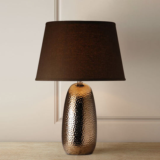 Rustic Hammered Ovoid Nightstand Lamp With Conical Fabric Shade In Brown For Bedroom