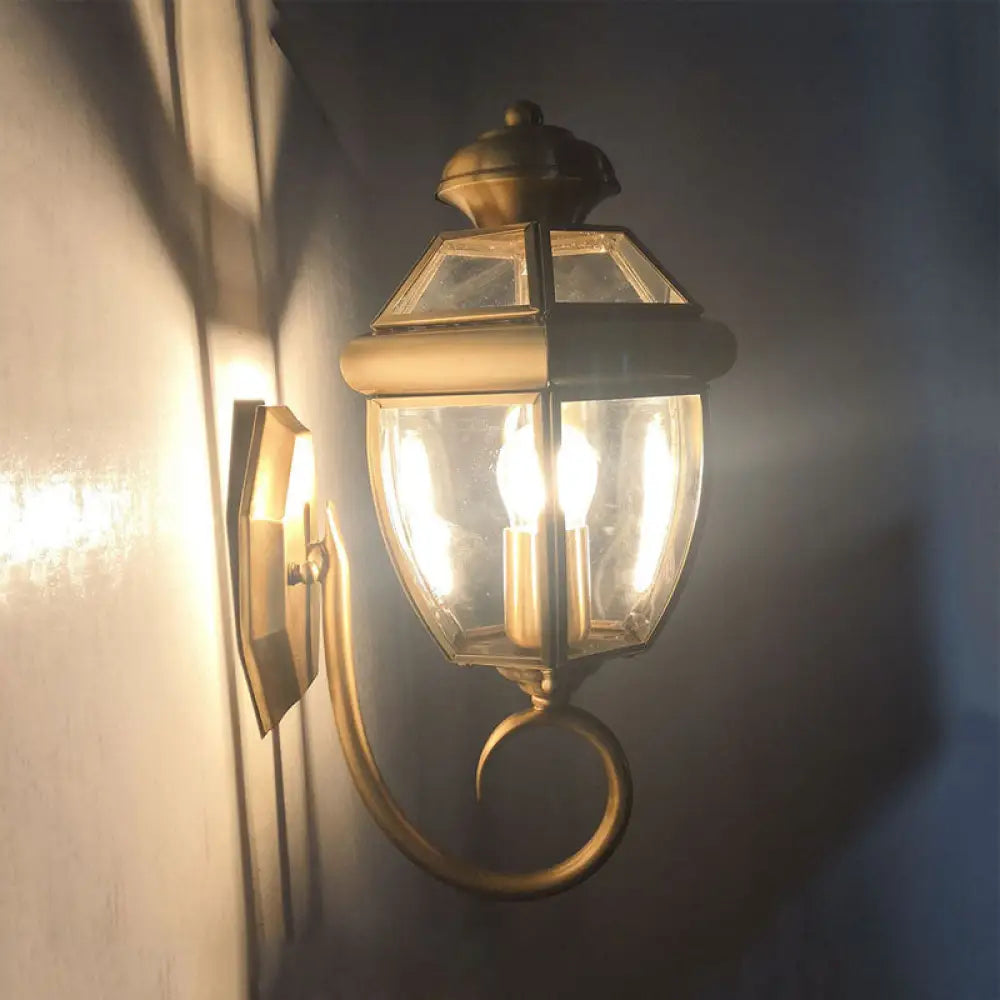 Brass Wall Sconce With Clear Glass Urn And Curved Arm Single Bulb Light Fixture