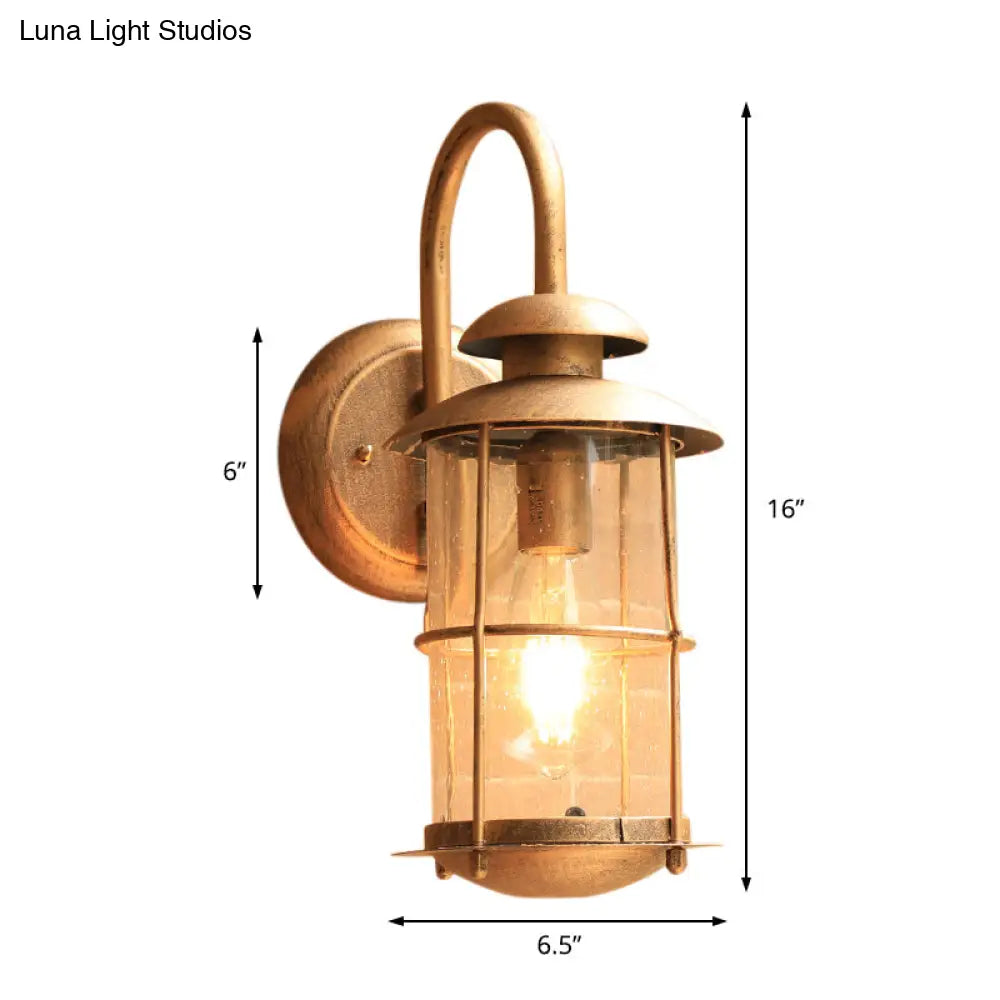 Coastal Clear Glass Wall Sconce With Brass Cage And Cylinder Light