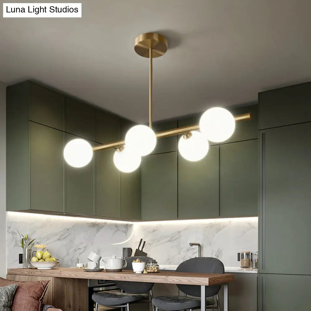 Linear Gold Pendant Light With Spherical Glass For Modern Minimalist Dining Table