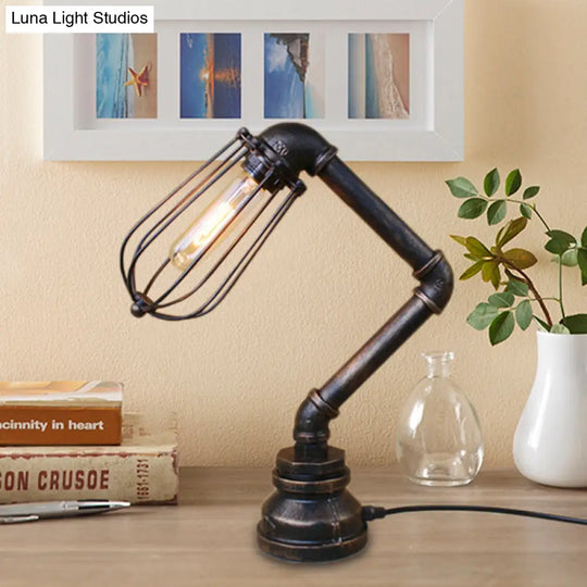 Industrial Style Metal Table Lamp With Bulb Cage Shade & Water Pipe In Aged Bronze