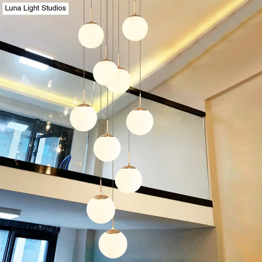 Minimalist Gold Multi-Pendant Ceiling Light With Cream Glass Bubbles And White Staircase Suspension