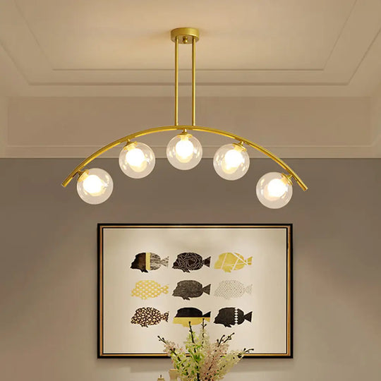 Modern Glass Orb Island Pendant Light With Brass Arch Arm - 5 Bulbs White/Clear Design For Dining