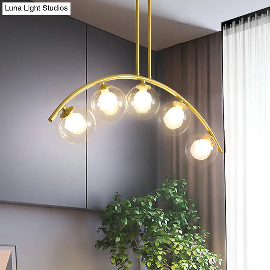 Modern Glass Orb Island Pendant Light With Brass Arch Arm - 5 Bulbs White/Clear Design For Dining