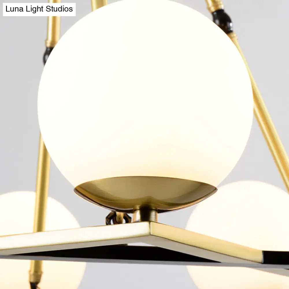 Postmodern Polygon Metal Chandelier With Brass Finish And Globe White Glass Shades