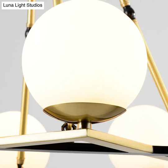 Postmodern Polygon Metal Chandelier With Brass Finish And Globe White Glass Shades