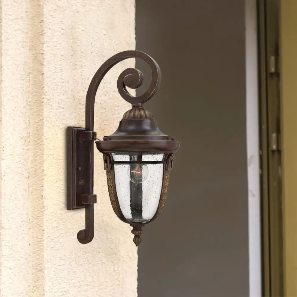 Rustic Bronze Scrolling Arm Metal Wall Lamp - 1 Light Outdoor Sconce With Seedy Glass Shade