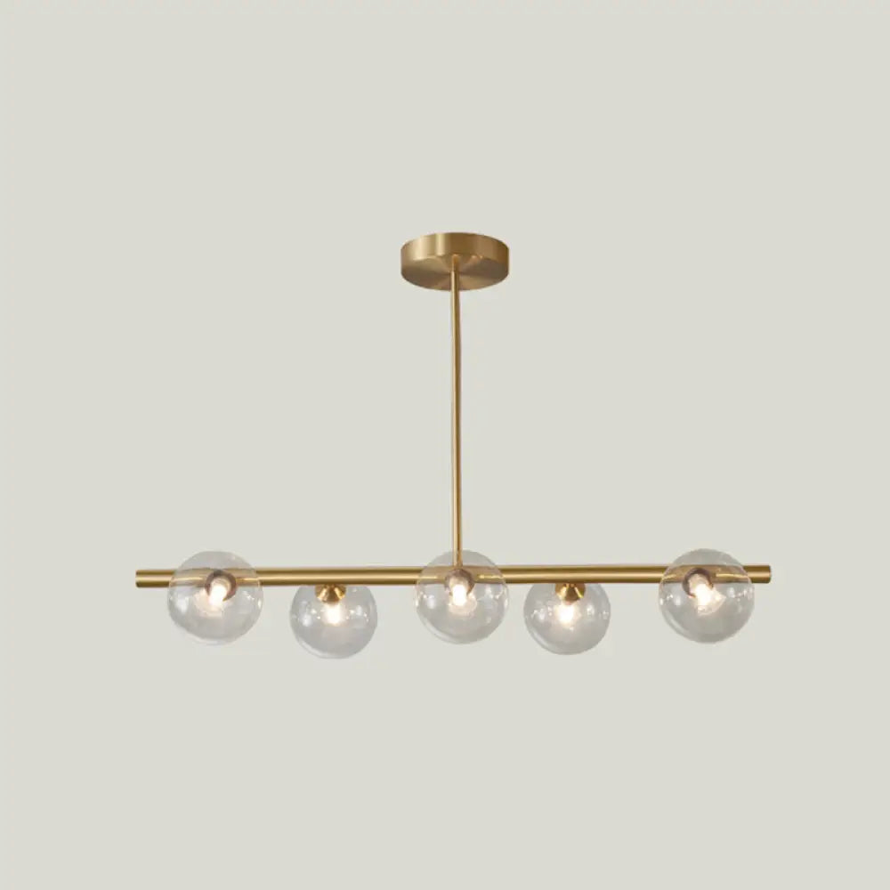 Sleek And Elegant Linear Gold Island Pendant Lighting With Spherical Glass Shades For Dining Table