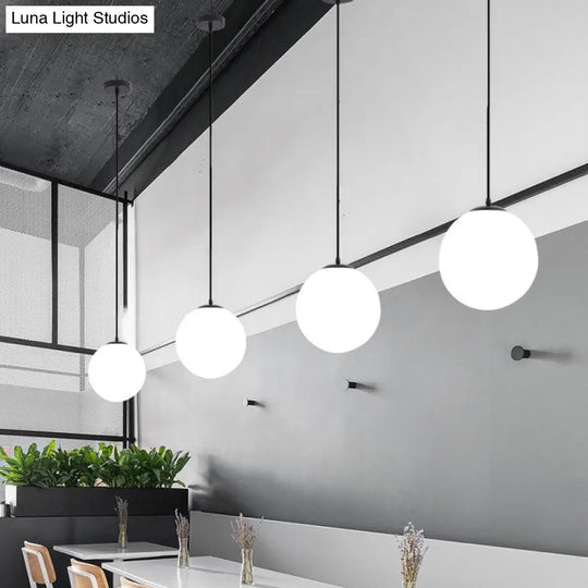 Sleek Black Sphere Restaurant Pendant Light With Cream Glass Shade - Simple Ceiling Hang Lamp