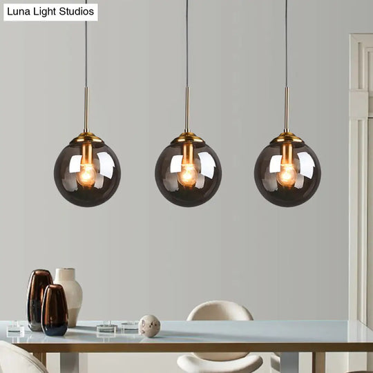 Sleek Brass Pendant Lamp With Amber/Smoke Glass Shade – Perfect For Dining Room Ceilings