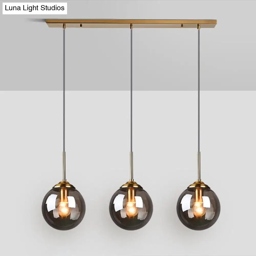 Sleek Glass 3-Bulb Spherical Ceiling Light Fixture In Brass For Minimalistic Dining Rooms