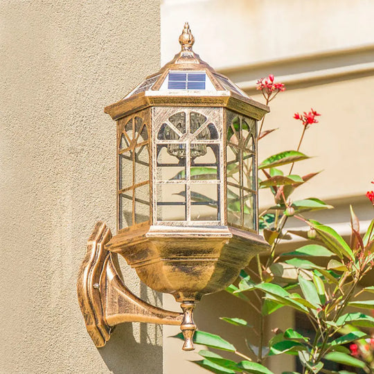 Traditional Outdoor Solar Wall Light Fixture With Metallic House Shaped Design And Clear Glass Shade